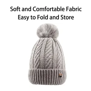 Women's knitted beanie with faux fur pompom and stylish cable knit texture in gray