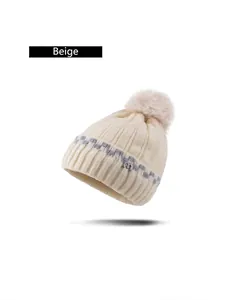 Beige Strickmütze mit Bommel und grauen Wellenmustern sowie kleinem m-Logo-Detail