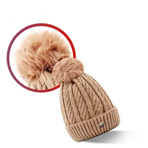 Winter camel cable knit beanie with fluffy faux fur pompom and metal emblem