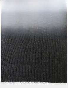 Detail of black thick knitted fabric showing vertical ribbed texture and grey trim