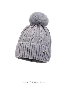 Grey winter knit beanie with fluffy pom pom, cable knit texture and H metal detail