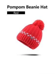 Dicke rote Strickmütze mit Bommel und Jacquard-Schachbrettmuster für kalte Wintertage