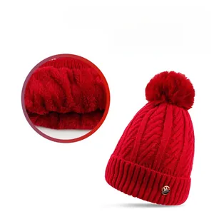 Detail of red knit beanie with faux fur lining and M logo for winter warmth