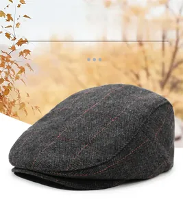 Detailed texture of charcoal grey herringbone newsboy cap made of thick wool fabric