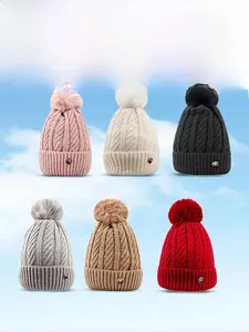 Detail display of six assorted colors of cuffed knit beanies with large faux fur pom-poms