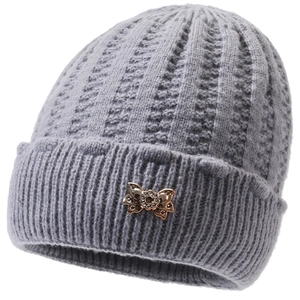 Detail of grey knitted hat with plush lining and bronze metallic butterfly buckle