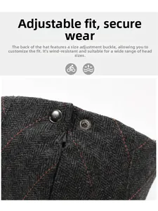 Detail of wool plaid beret featuring adjustable metal snap button and red stitching