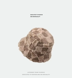 Close-up of beige and brown checkered faux fur texture on a plush bucket hat