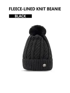 Detail of black knit beanie with plush lining, fluffy pom-pom and metallic M logo