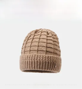 Close-up of camel knit winter hat with textured grid pattern and pearl flower brooch