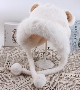 Détail du bonnet d'ours en fausse fourrure crème avec pompons et oreilles brunes