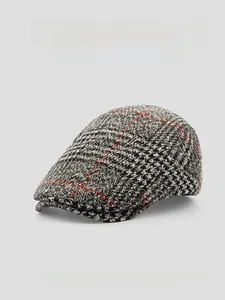 Detail of grey plaid wool beret featuring 3D tailoring and classic red check pattern