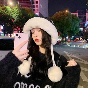 Detailed view of winter trapper hat featuring white faux fur trim and large fluffy pom-poms
