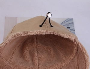 Close-up of winter hat featuring thick faux shearling lining and metal buckle toggle