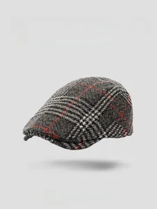 Detailed view of gray plaid wool beret cap with red accents and reinforced brim