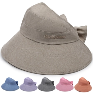 Detail of wide brim sun hat showing linen texture, bow accent, and multiple color options