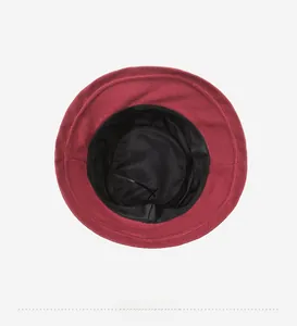 Detail view showing dark red wool cloche hat interior with black lining and chin strap