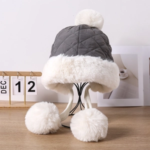 Winter plush trapper hat with quilted fabric and faux fur pom-poms for ear protection