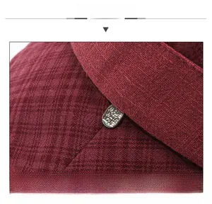 Detailed close-up of wine red textured fabric hat with engraved metal label