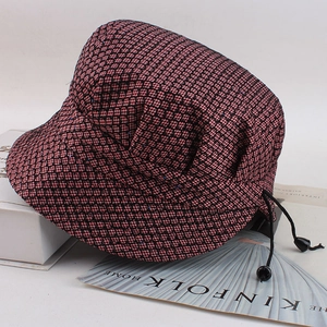 Close-up of pink and black plaid elder hat with blue sequins and adjustable drawstring