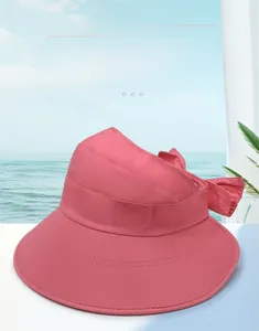 Detailed view of pink sun visor hat with wide brim, embroidery logo and rear bow knot