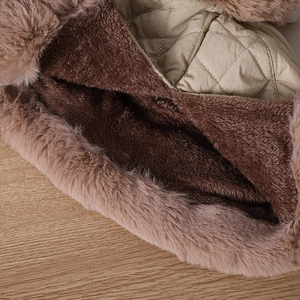 Detailed close-up of winter hat's thick faux fur lining and khaki quilted fabric texture