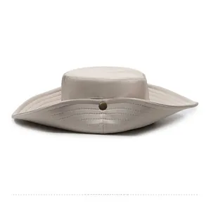 Detail view of beige canvas sun hat featuring wide brim stitching and a vintage metal button