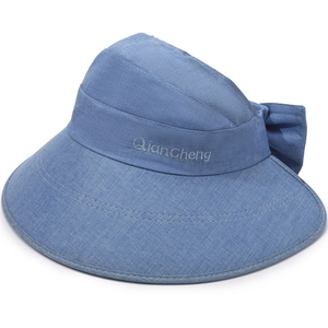 Detailed view of light blue linen sun hat featuring wide brim and large bow decoration