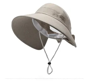 Detail of wide brim sun hat featuring beige linen texture and adjustable chin strap