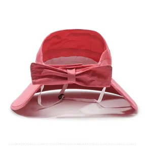 Detail of pink sun hat featuring a large decorative bow and adjustable chin strap