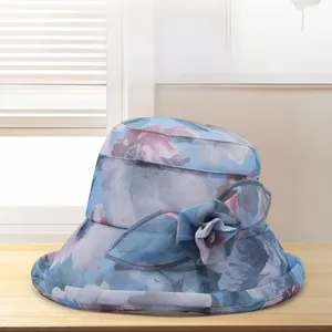 Detail of light blue floral chiffon sun hat with 3D flower accent on wooden surface