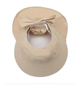 Top view of beige wide brim sun hat showing the empty top design and rear bow detail