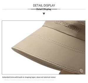 Close-up of the beige sun hat's wide brim featuring reinforced stitching and metal snaps