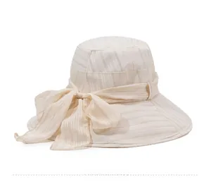 Close-up of beige wide brim sun hat with vertical texture and decorative ribbon bow