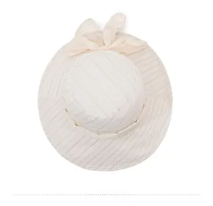 Top view of a beige wide-brim sun hat with vertical stripes and a large bow detail