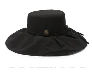 Side view of black breathable wide brim sun hat with metallic button and ribbon detail