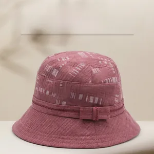 Dettaglio della corona strutturata e della trama geometrica rosa sul cappello a secchiello