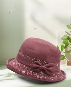 Détail du chapeau cloche bordeaux avec nœud décoratif et motifs géométriques
