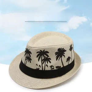 Detail of beige straw jazz hat featuring black palm tree prints and a stylish decorative band