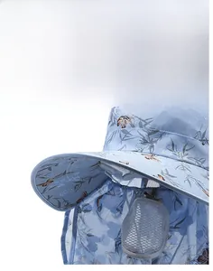 Détail du chapeau de soleil bleu clair à motif floral, large bord et masque en maille