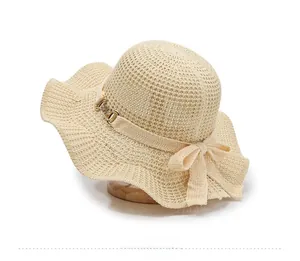 Detail of crochet sun hat featuring wavy brim and elegant ribbon with gold buckle