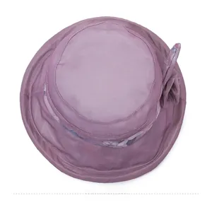Vue de dessus d'un chapeau de soleil violet pour femmes avec décoration florale en tissu