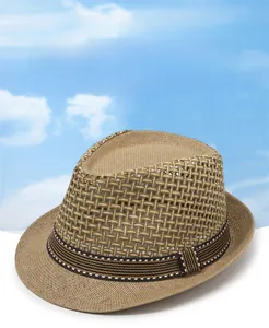 Gros plan d'un chapeau de paille tissé ajouré avec ruban rayé sombre décoratif