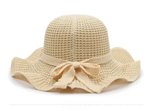 Detail of beige knit sun hat showing crochet texture and elegant bow decoration