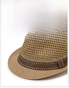 Gros plan sur la texture en paille tressée et le ruban rayé d'un chapeau de jazz kaki