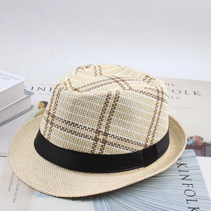 Détail d'un chapeau de paille tressé avec motif à carreaux et ruban noir élégant