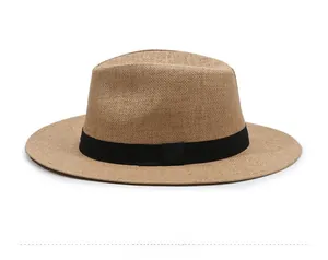 Detailed side view of brown woven straw sun hat with black grosgrain ribbon band