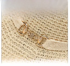Macro detail of the woven straw texture and elegant gold metal flower buckle on the sun hat