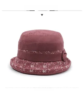 Détail chapeau cloche bordeaux avec motifs floraux géométriques et texture rayée élégante