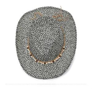 Top down view of woven cowboy straw hat with brown wooden beads and decorative string
